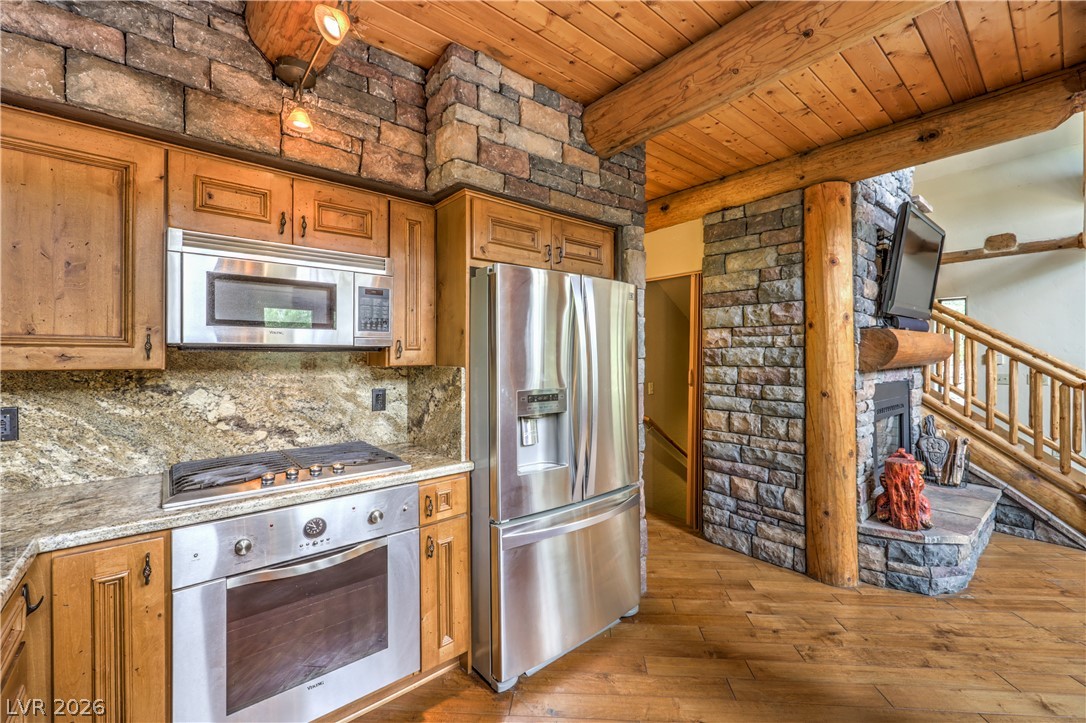 322 Ski Trail Road Mount Charleston, NV 89124 - Photo 17 of 58 Rich wood plank ceilings and stone accents frame this rustic mountain-style cooking space.