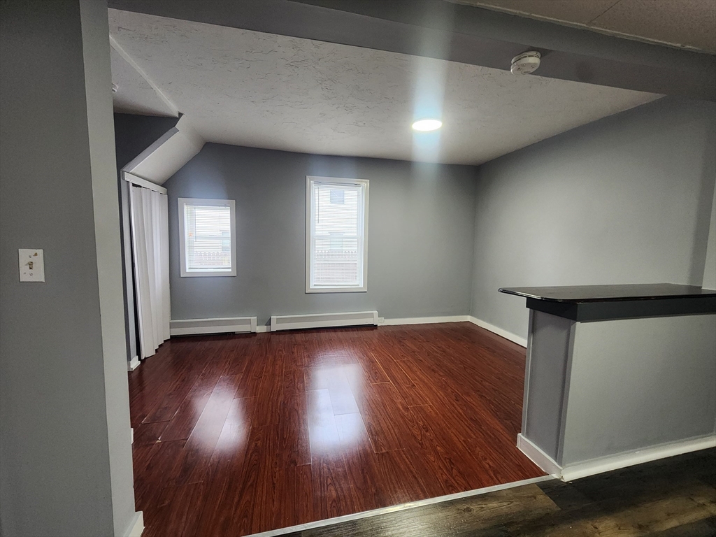 7 Pleasant Terrace, Unit 1 Worcester, MA 01609 - Photo 5 of 10 an empty room with wooden floor and windows