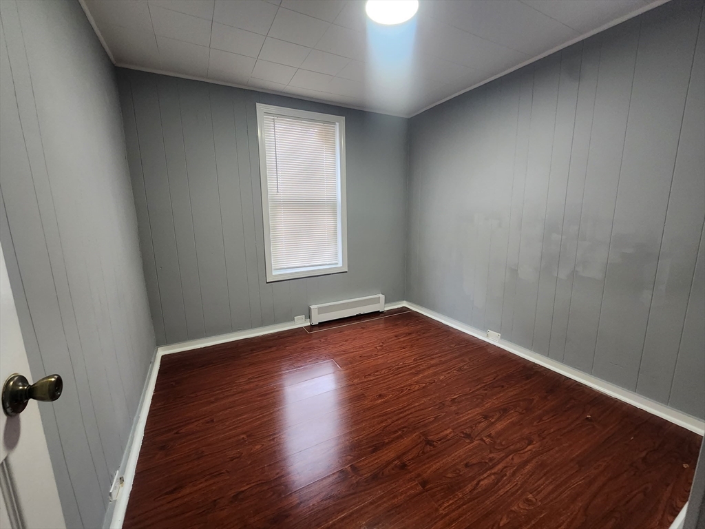 7 Pleasant Terrace, Unit 1 Worcester, MA 01609 - Photo 6 of 10 an empty room with wooden floor and windows