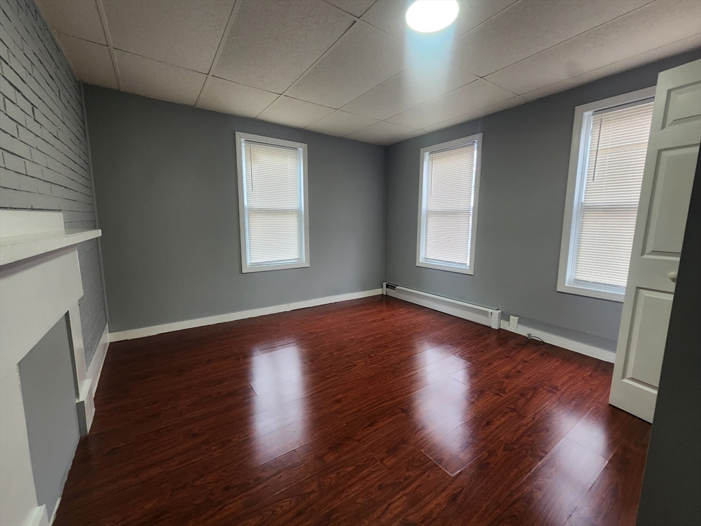 7 Pleasant Terrace, Unit 1 Worcester, MA 01609 - Photo 7 of 10 an empty room with wooden floor and window