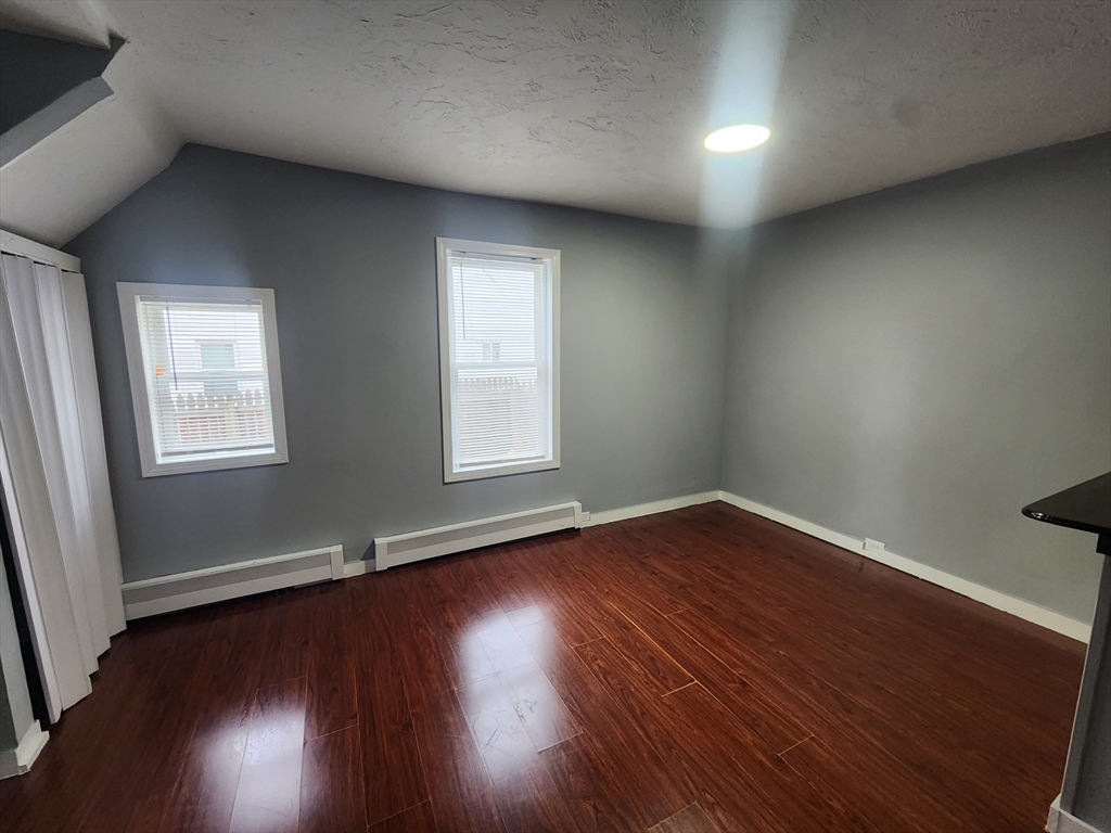 7 Pleasant Terrace, Unit 1 Worcester, MA 01609 - Photo 9 of 10 an empty room with wooden floor and windows