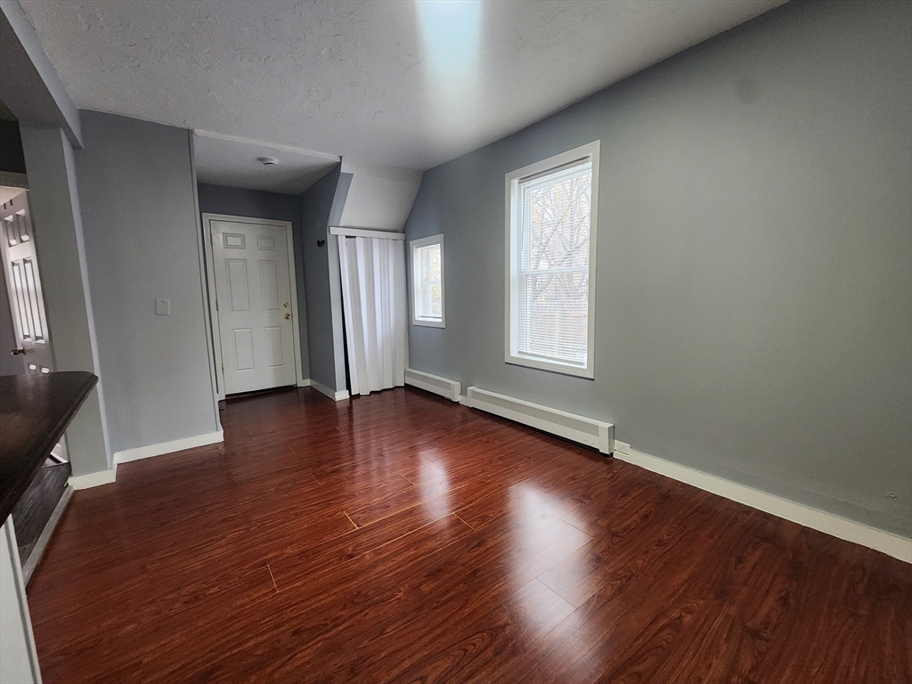7 Pleasant Terrace, Unit 1 Worcester, MA 01609 - Photo 10 of 10 an empty room with wooden floor and windows
