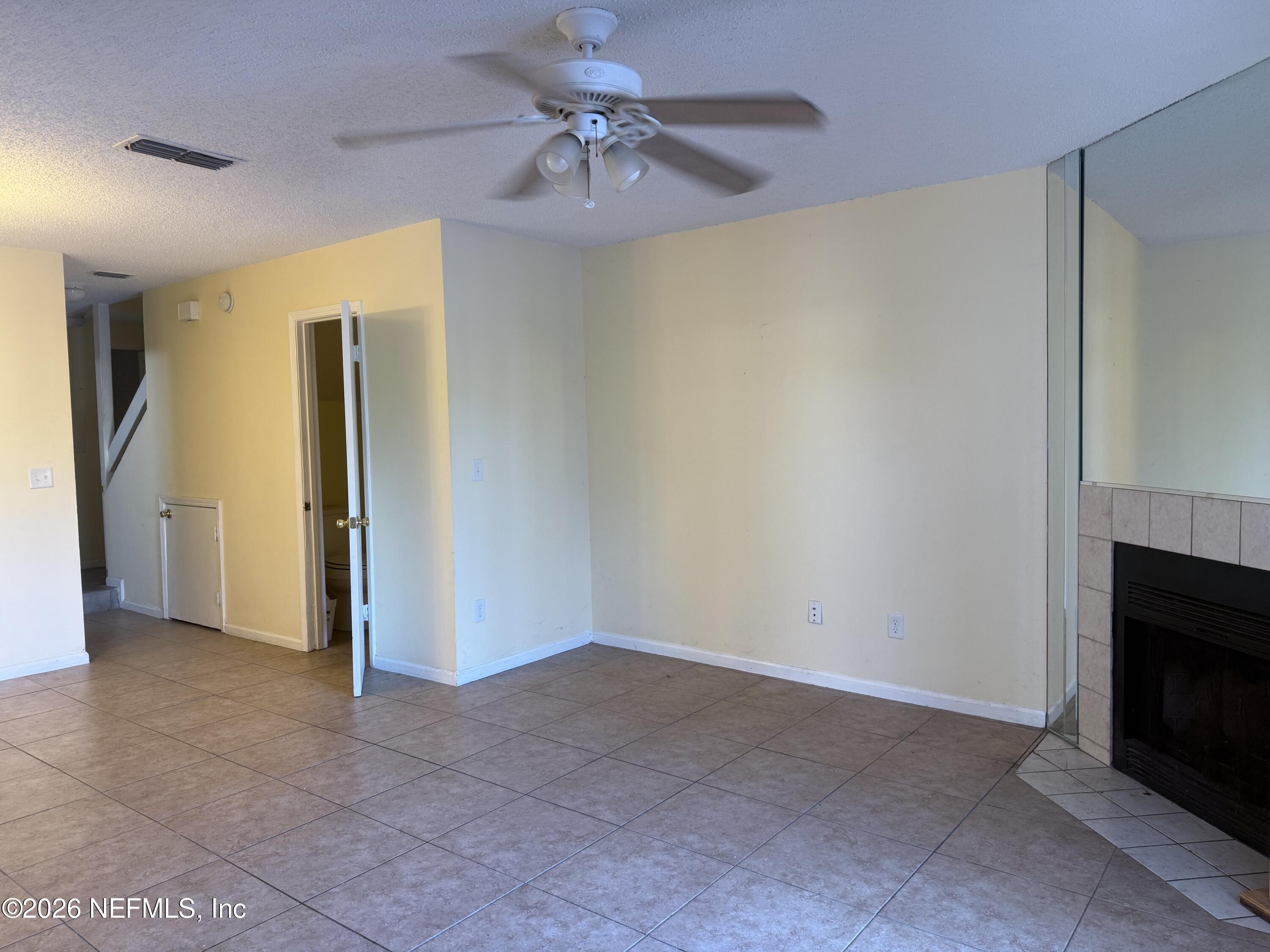 3801 Crown Point Road, Unit 2093 Jacksonville, FL 32257 - Photo 3 of 17 a view of empty room with fan and a fireplace
