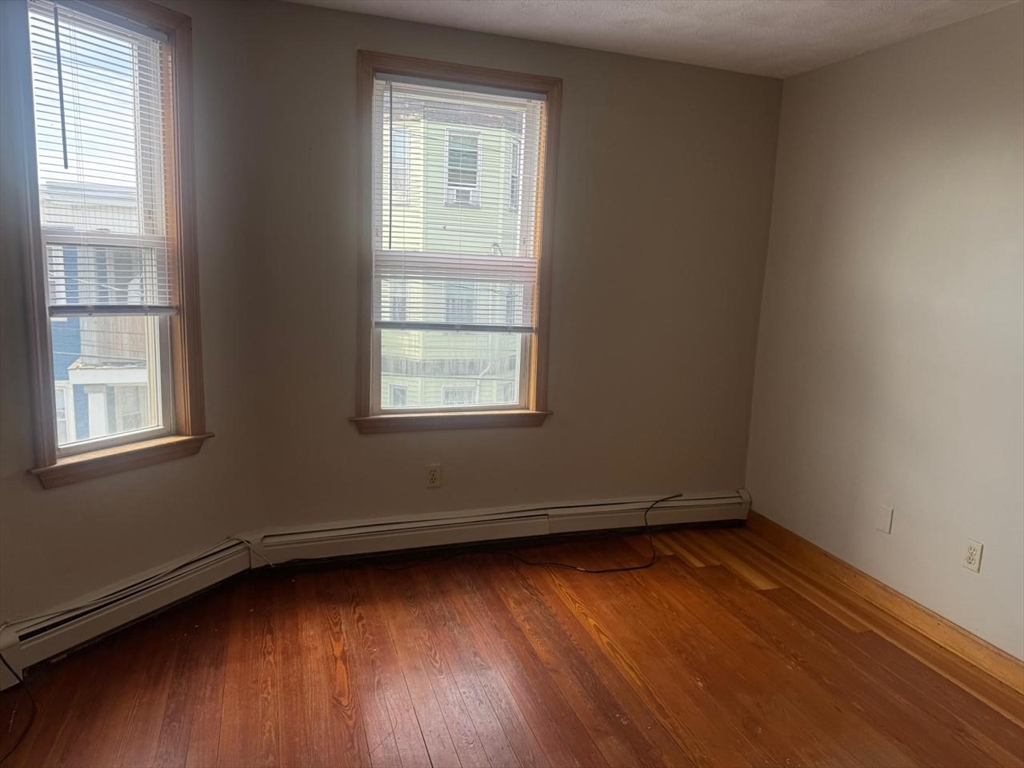 68 Maverick Street Chelsea, MA 02150 - Photo 10 of 16 an empty room with wooden floor and windows