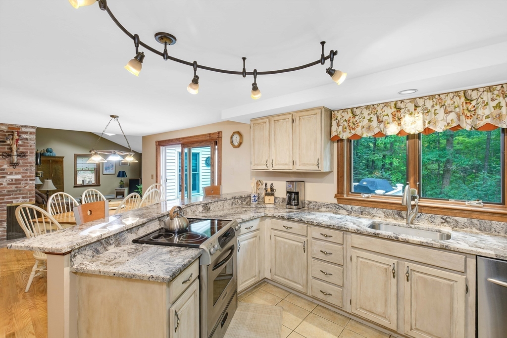 156 Newbury Road Rowley, MA 01969 - Photo 4 of 41 a kitchen with granite countertop a sink appliances cabinets and a large window