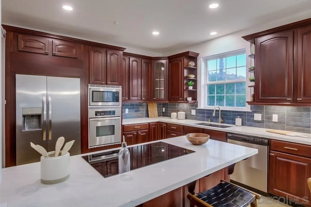 2543 Daisy Lane Fallbrook, CA 92028 - Photo 38 of 74 a kitchen with kitchen island a large counter top space appliances and a sink
