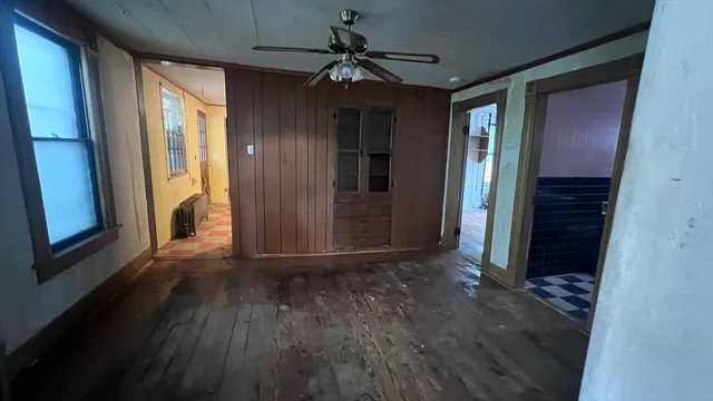 a view of a hallway with wooden floor and a chandelier
