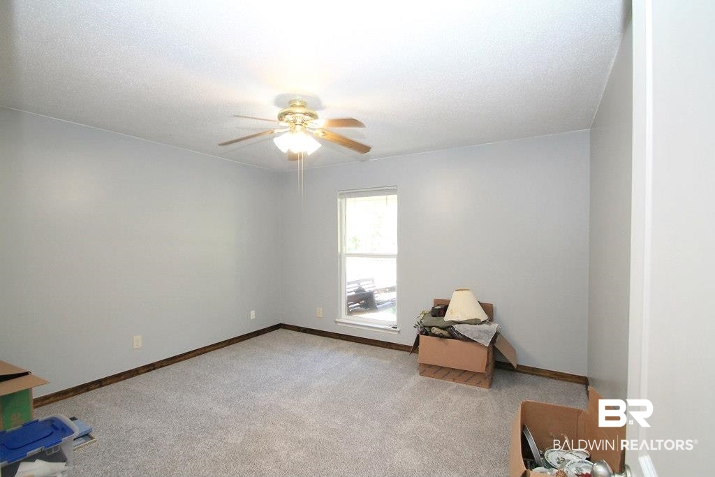 205 Montclair Loop Daphne, AL 36526 - Photo 11 of 19 Unfurnished room with light carpet, ceiling fan, and a textured ceiling