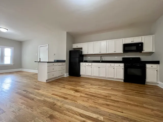 a kitchen with granite countertop a stove top oven sink and cabinets