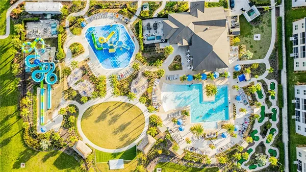 an aerial view of a swimming pool with outdoor seating and garden