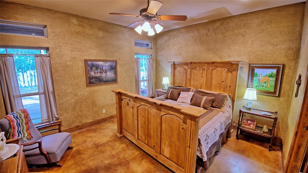 4509 Lazy E Road St. Jo, TX 76265 - Photo 9 of 39 a bed room with a bed and a chandelier