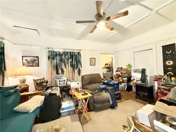 a living room with furniture kitchen view and a large window