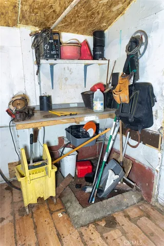 a room with water heater and wooden cabinets