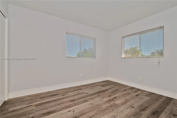 a view of a room with wooden floor and window