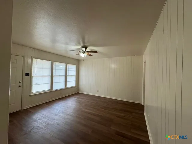 a view of a livingroom with a ceiling fan and window