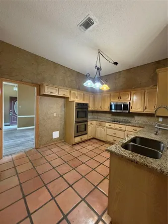 a kitchen with stainless steel appliances granite countertop a sink and a stove