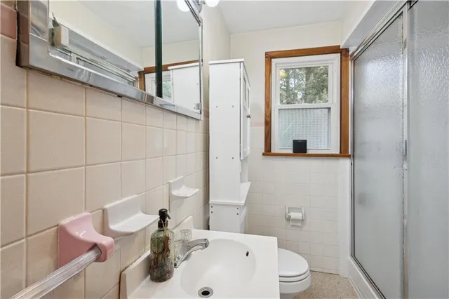 a bathroom with a sink a toilet and shower