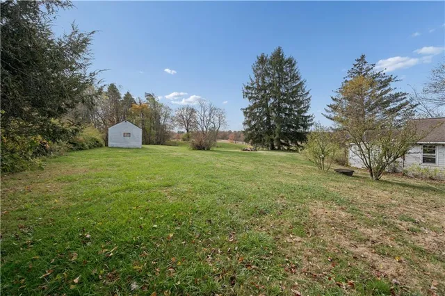 a view of a field with a house in the background