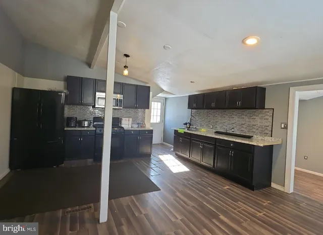 a kitchen with stainless steel appliances wooden floors and wooden cabinets