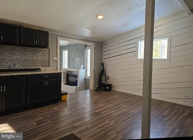 a kitchen with granite countertop wooden cabinets and a wooden floor