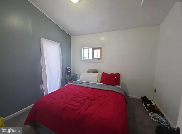 a bed sitting in a bedroom next to a window