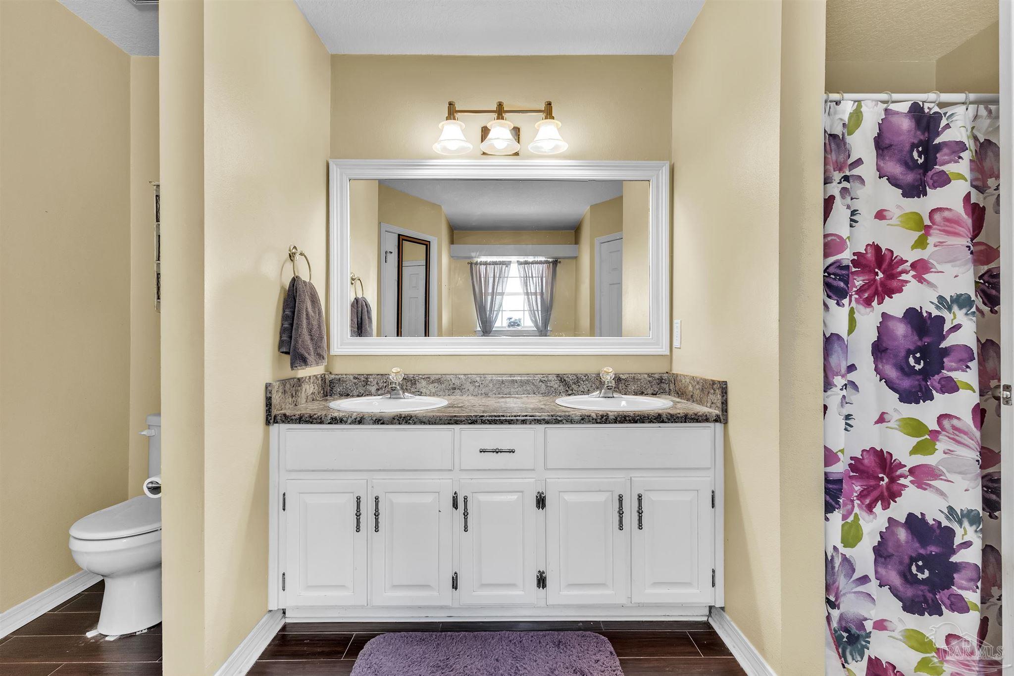 4321 Ridgeland Drive Pace, FL 32571 - Photo 18 of 36 a bathroom with a granite countertop sink a toilet and a mirror