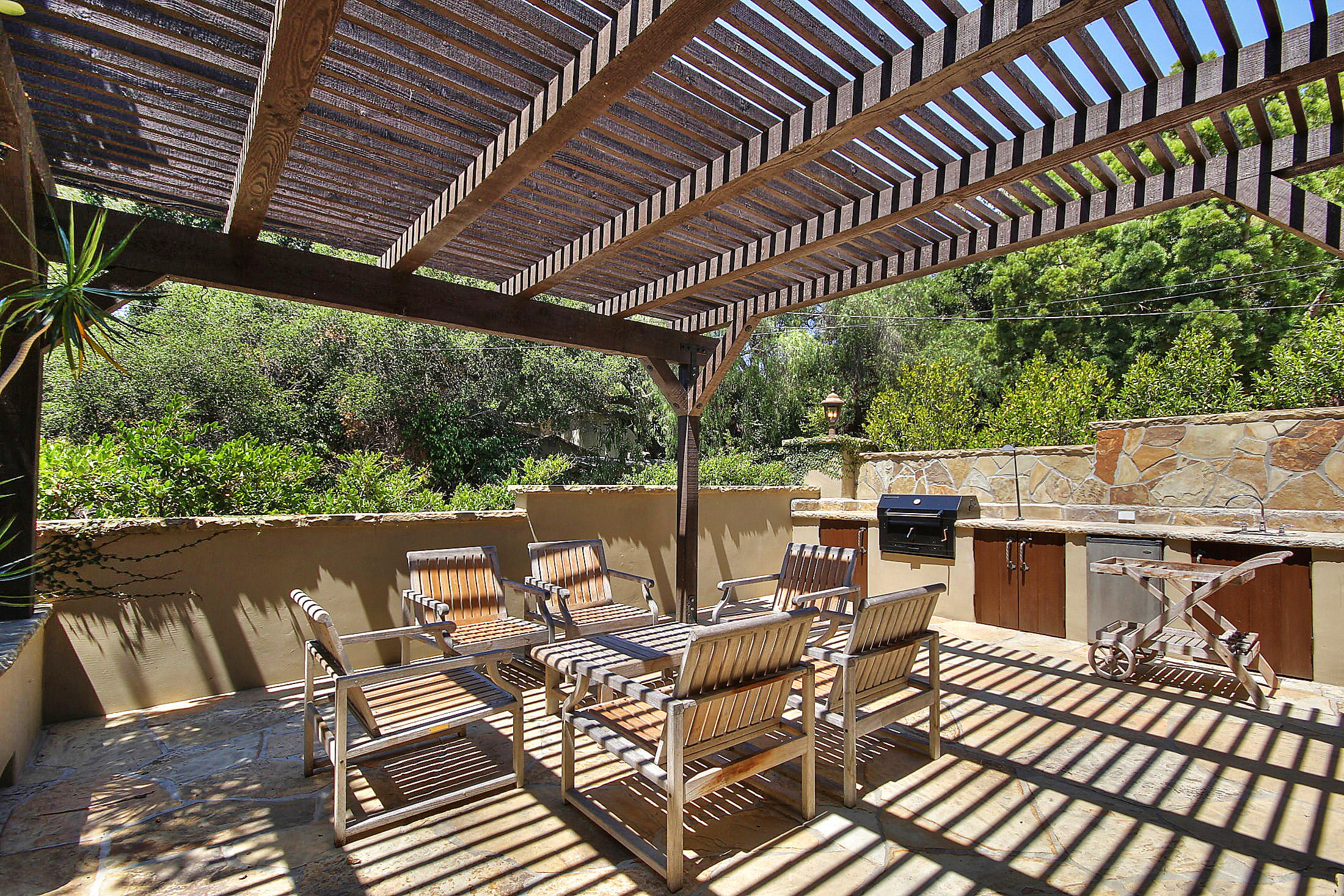 2540 Foothill Road Santa Barbara, CA 93105 - Photo 16 of 45 a view of a patio with table and chairs barbeque potted plants and large tree