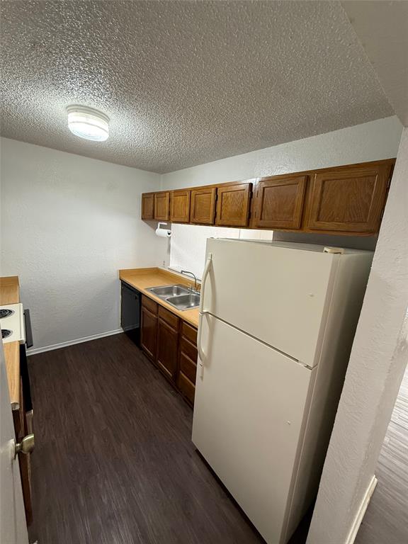 1715 Short Street, Unit D Cleburne, TX 76033 - Photo 10 of 12 Kitchen featuring wood-finish flooring, wood cabinetry, laminate countertops, and a double basin stainless steel sink