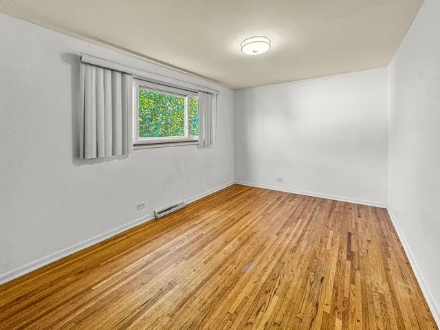 a view of a room with wooden floor and window