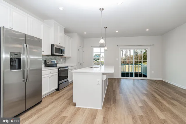 a kitchen with stainless steel appliances a refrigerator sink and microwave