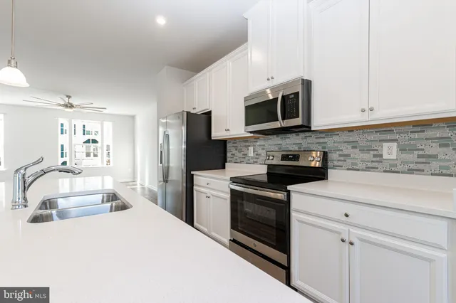 a kitchen with stainless steel appliances granite countertop a refrigerator stove microwave and sink