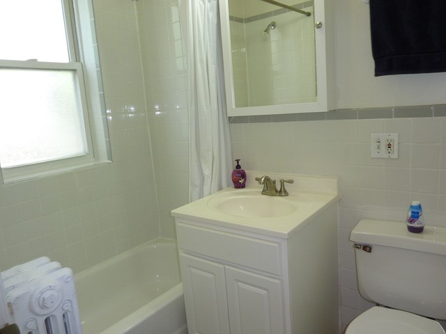 5058 North Claremont Avenue, Unit 2E Chicago, IL 60625 - Photo 12 of 12 a bathroom with a sink a toilet and shower