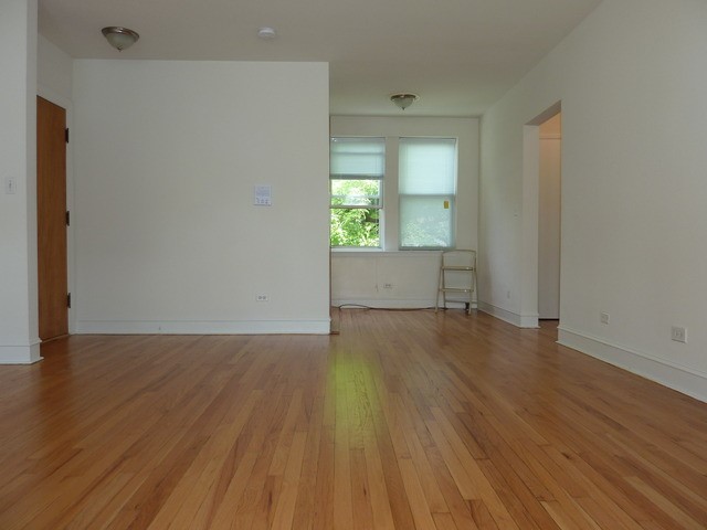 5058 North Claremont Avenue, Unit 2E Chicago, IL 60625 - Photo 6 of 12 an empty room with wooden floor and windows
