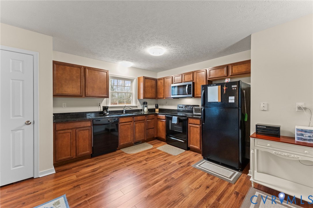 388 Berry Ridge Road Tappahannock, VA 22560 - Photo 7 of 25 a kitchen with granite countertop stainless steel appliances and wooden cabinets