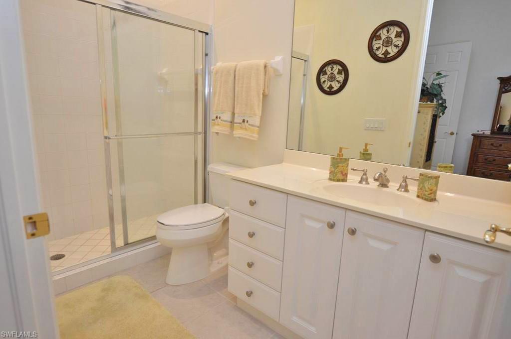 9267 Museo Circle, Unit 204 Naples, FL 34114 - Photo 18 of 24 a bathroom with a toilet a sink a mirror and a shower