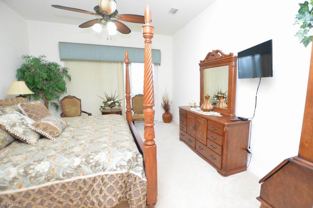 9267 Museo Circle, Unit 204 Naples, FL 34114 - Photo 20 of 24 a bedroom with a large bed and a flat tv screen on dresser