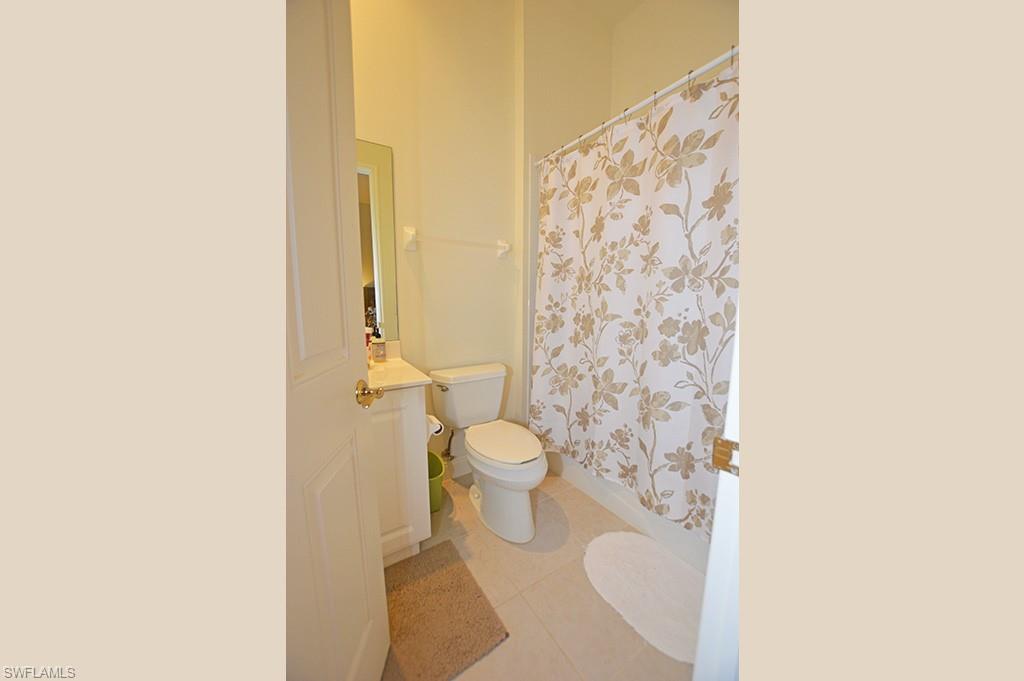 9267 Museo Circle, Unit 204 Naples, FL 34114 - Photo 21 of 24 a bathroom with a toilet and a shower curtain