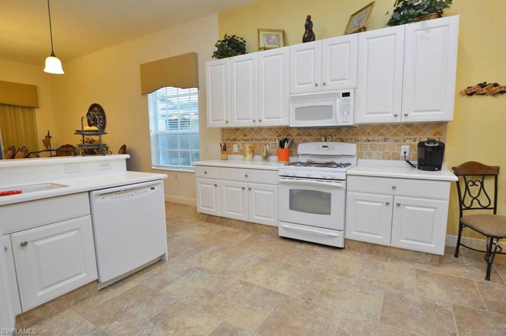 9267 Museo Circle, Unit 204 Naples, FL 34114 - Photo 10 of 24 a kitchen with white cabinets and white appliances