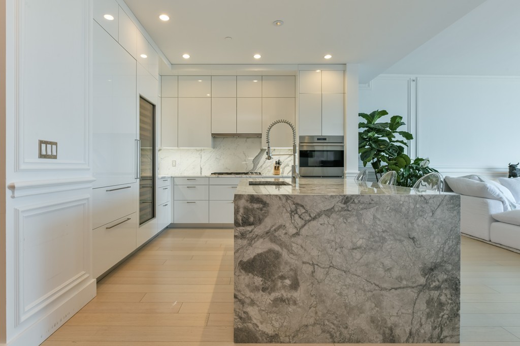 1 Franklin Street, Unit 5201 Boston, MA 02110 - Photo 11 of 23 a large kitchen with stainless steel appliances kitchen island granite countertop a sink and cabinets