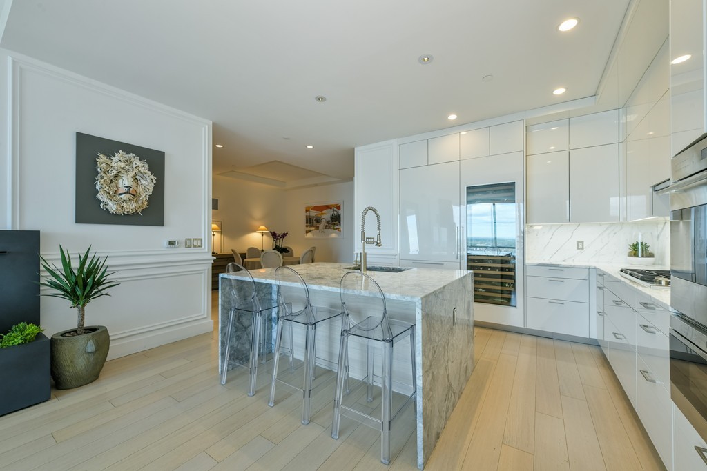 1 Franklin Street, Unit 5201 Boston, MA 02110 - Photo 14 of 23 a kitchen with white cabinets and wooden floor