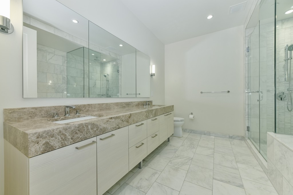 1 Franklin Street, Unit 5201 Boston, MA 02110 - Photo 21 of 23 a bathroom with a granite countertop sink and a mirror