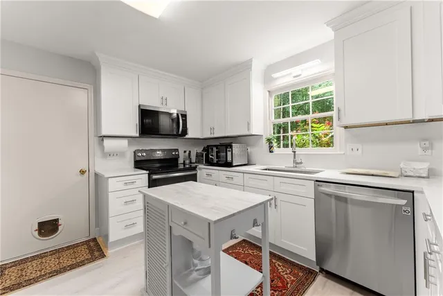 a kitchen with stainless steel appliances a refrigerator stove top oven and sink