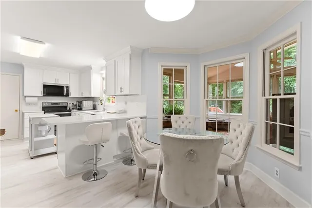a dining room with furniture and large windows
