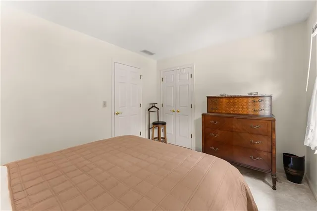 a bedroom with a bed a book shelf and a window