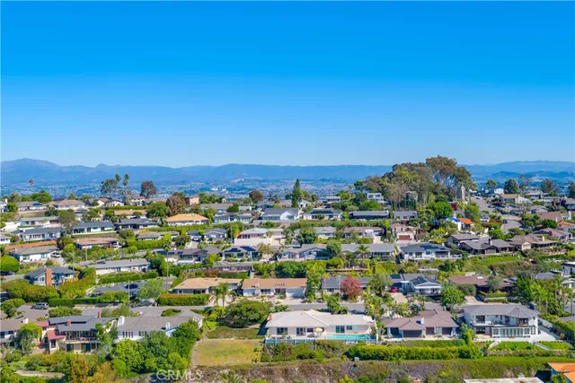 an aerial view of a house with a garden and lake view