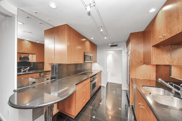 a large kitchen with kitchen island a sink stainless steel appliances and cabinets