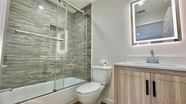 a bathroom with a granite countertop toilet sink and shower