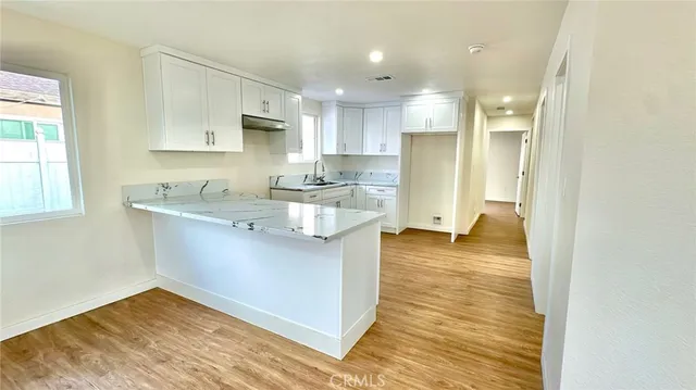 a kitchen with kitchen island a sink stainless steel appliances and cabinets