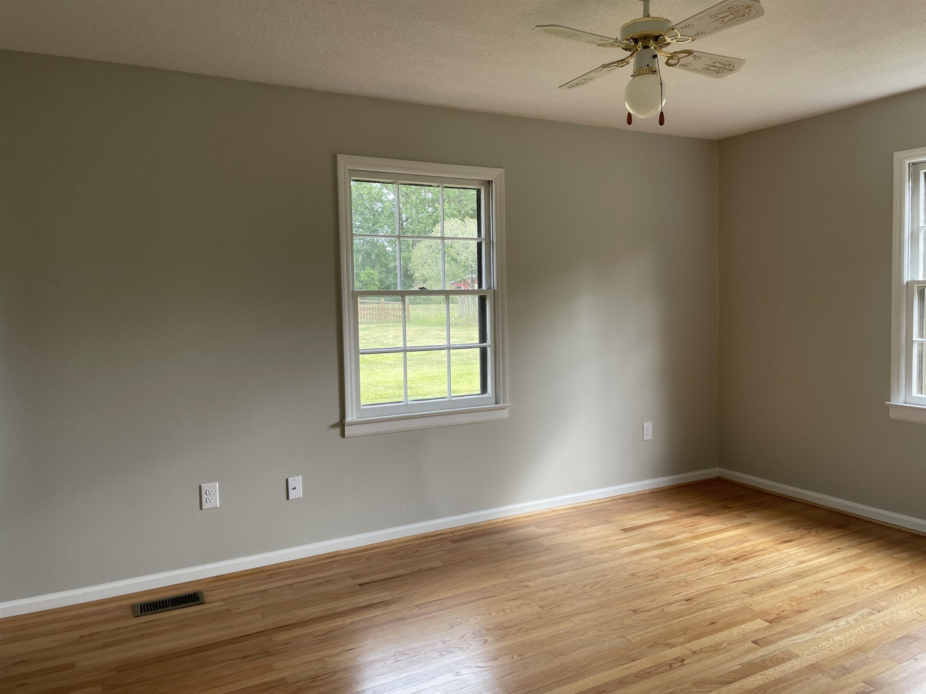 3418 Cheek Road Durham, NC 27704 - Photo 6 of 12 an empty room with wooden floor and windows