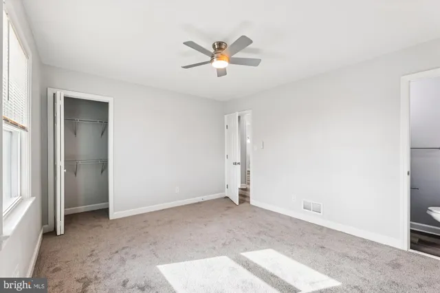 a view of a livingroom with a ceiling fan and window